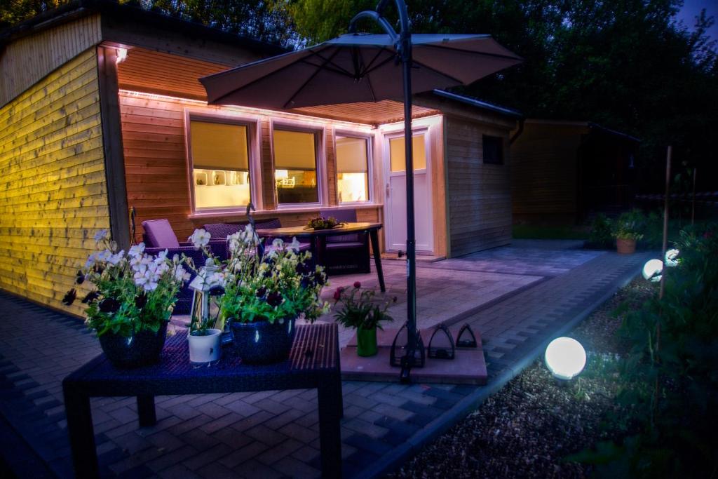 patio con ombrellone e tavolo con piante di Ferienhaus Am Lutherweg a Seeburg