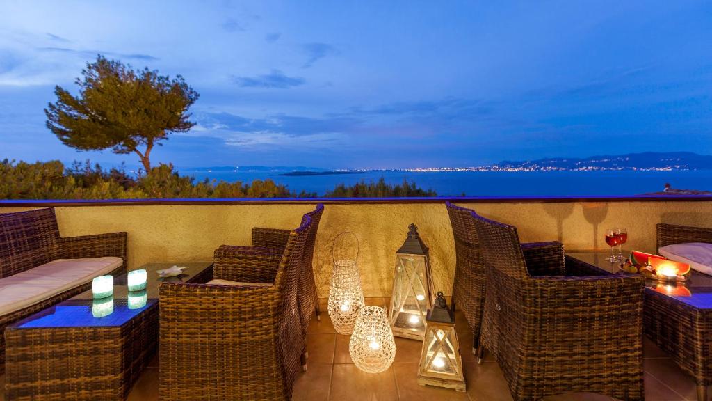 einen Balkon mit Korbstühlen und einem Tisch mit Kerzen in der Unterkunft Hotel Abatis in Megalochori