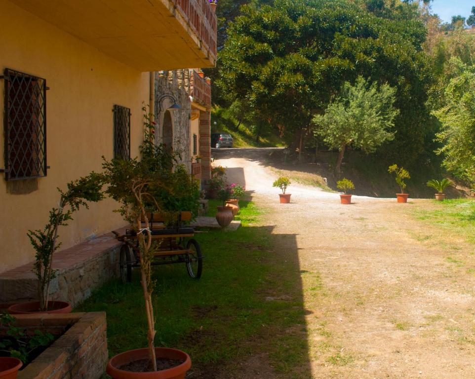 Una casa con macetas al costado. en Agriturismo Fattoria di Grenne en Ficarra