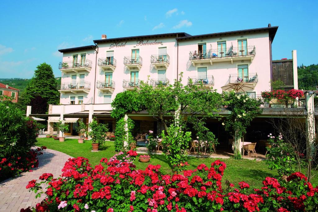 a large pink building with flowers in front of it at Hotel Belvedere in Torri del Benaco