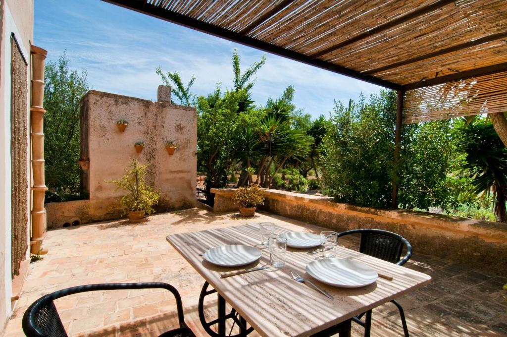 a wooden table and chairs on a patio at Es Rafal Roig (Verd) in Manacor