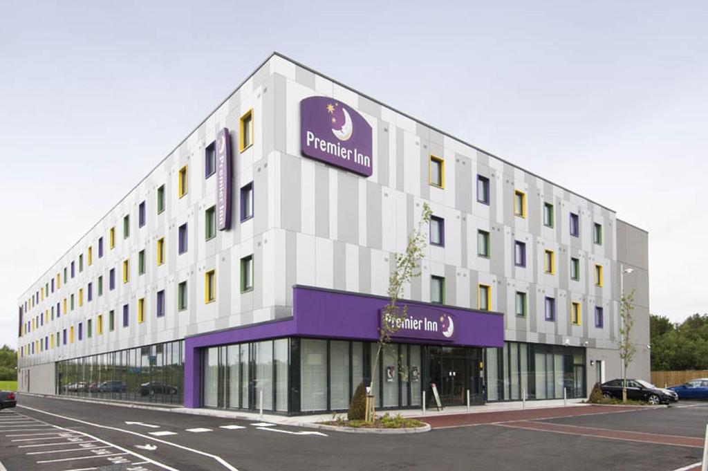 a large building with a sign on the side of it at Premier Inn London Stansted Airport in Stansted Mountfitchet