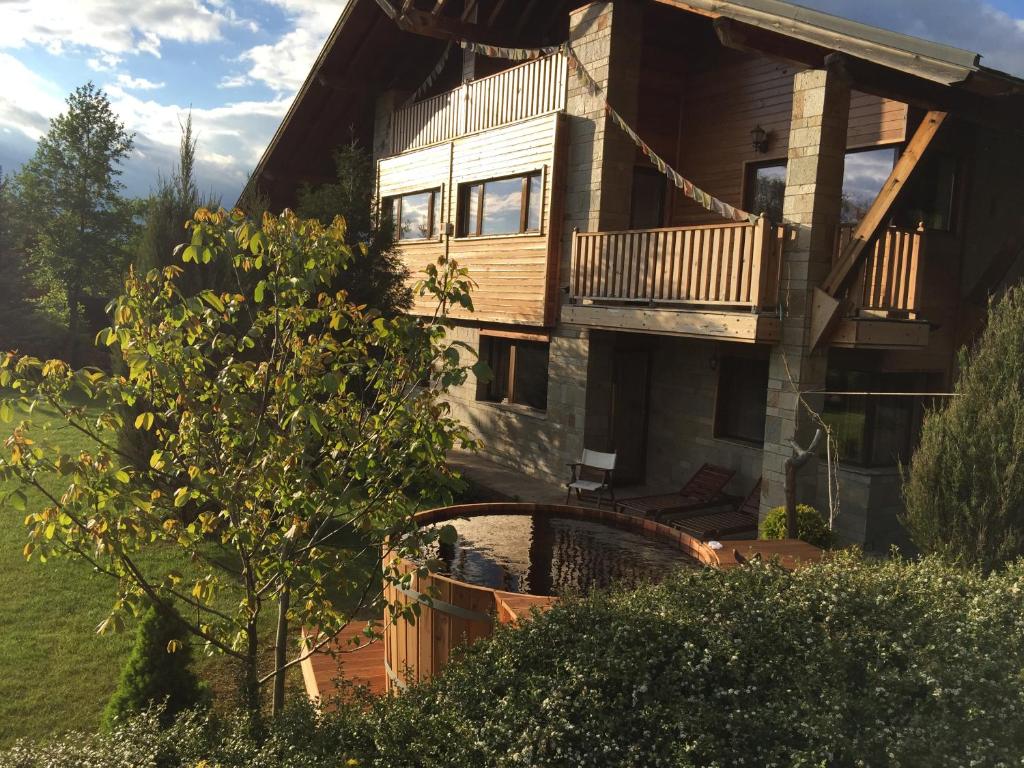 a log house with a balcony and a tree at Villa Chalet Everest in Bansko