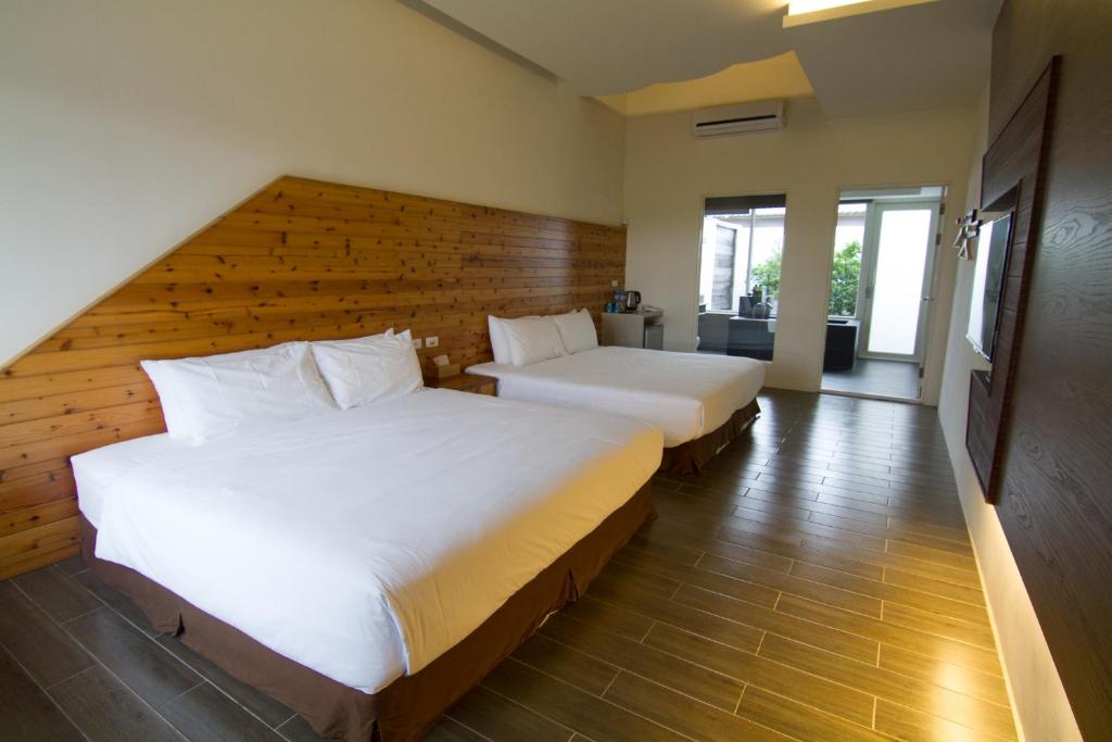 2 Betten in einem Hotelzimmer mit 2 Betten sidx sidx sidx sidx in der Unterkunft Kenting Xia Ye B&B in Altstadt von Hengchun