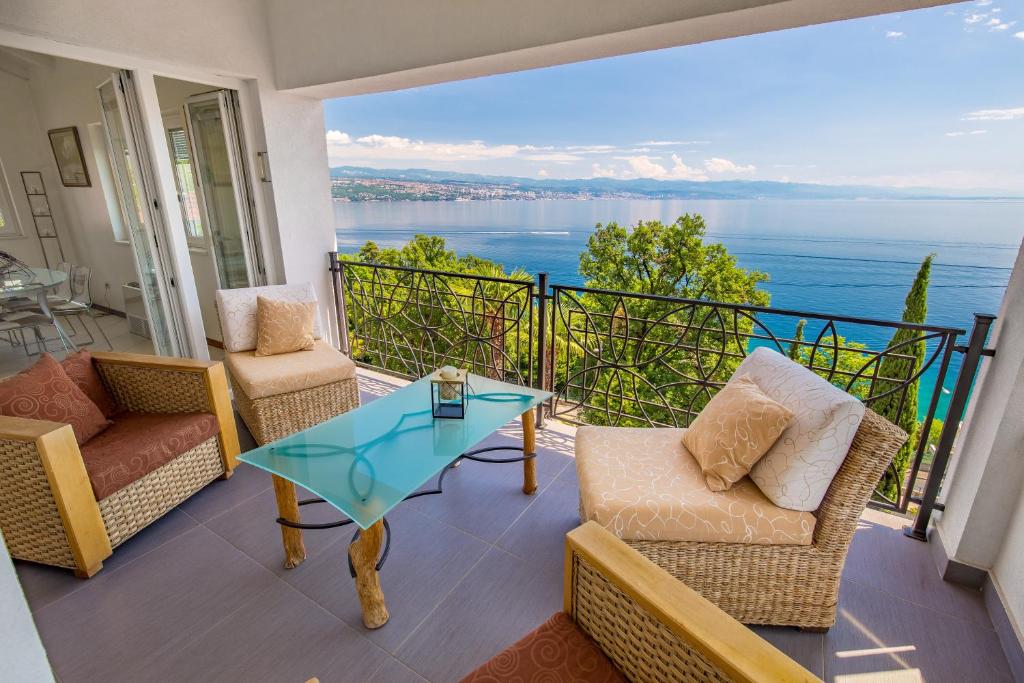 einen Balkon mit Stühlen und einem Glastisch in der Unterkunft Luxury penthouse Prestige near the sea in Opatija