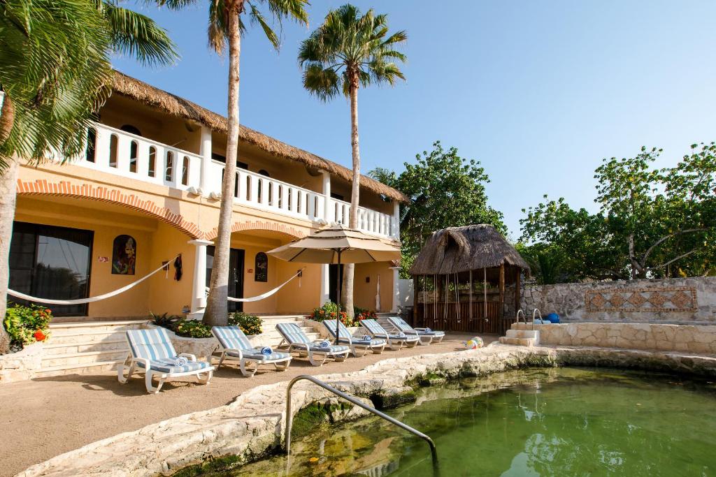 uma casa com cadeiras e uma piscina em Chez Waffle Hotel em Puerto Aventuras