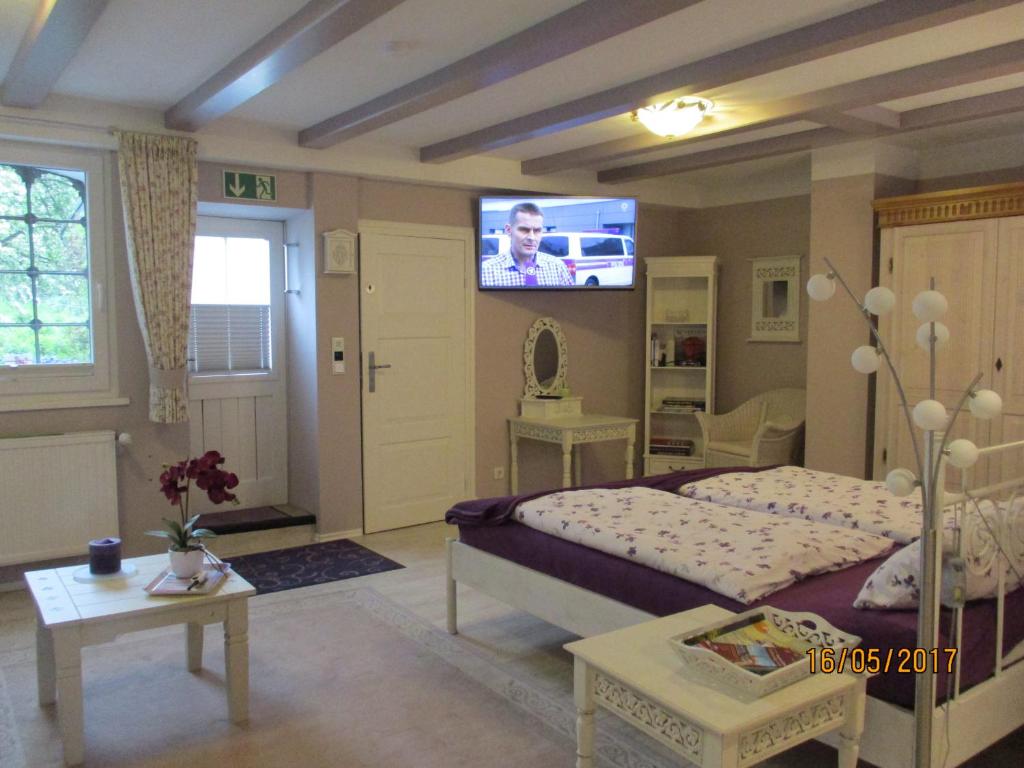 a bedroom with a bed and a tv on the wall at Pension Alte Bäckerei in Kosel in Kosel
