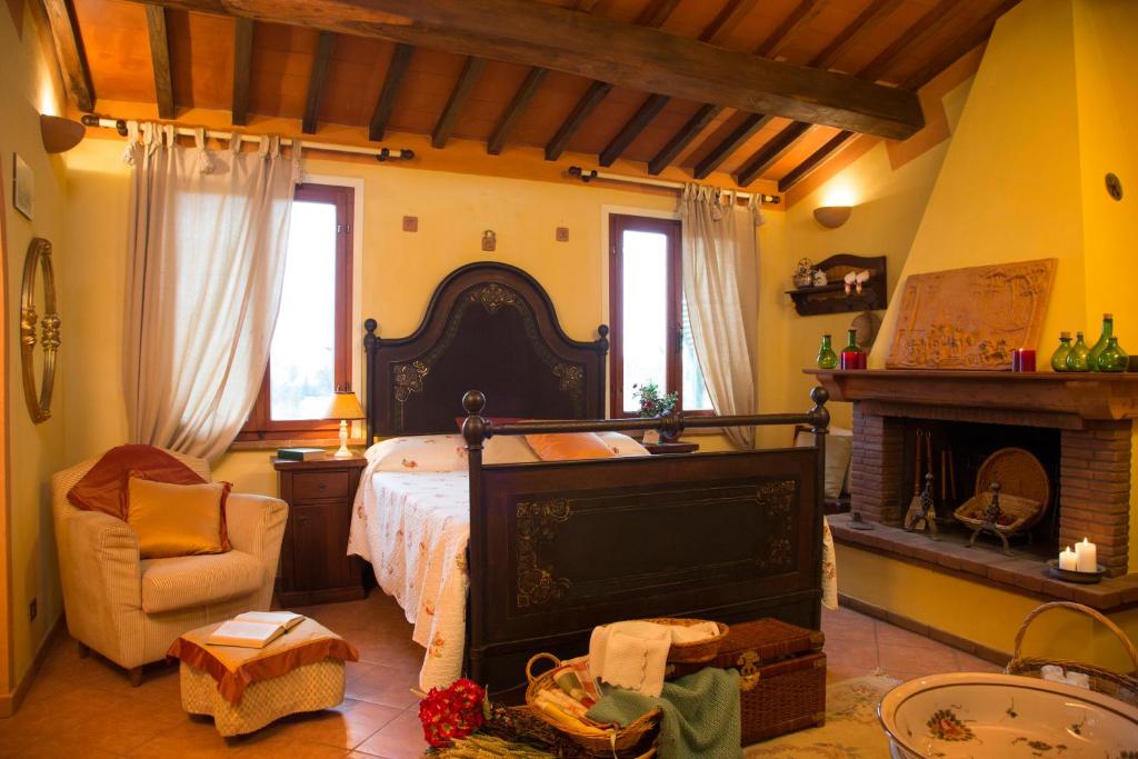 a bedroom with a large bed and a fireplace at Il Frutteto in Lari