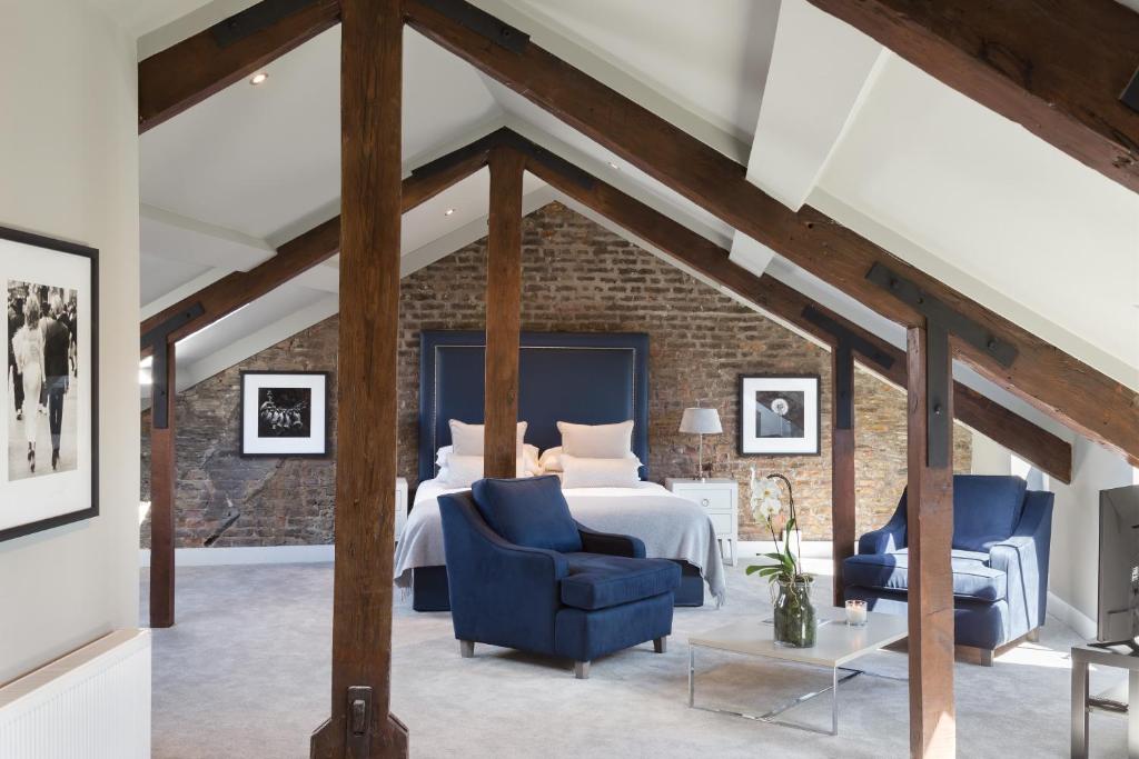 1 dormitorio con 1 cama y 2 sillas azules en Giles Norman Gallery & Townhouse en Kinsale