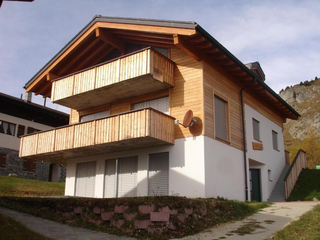 a house with wooden balconies on the side of it at Apartment Amore in Riederalp