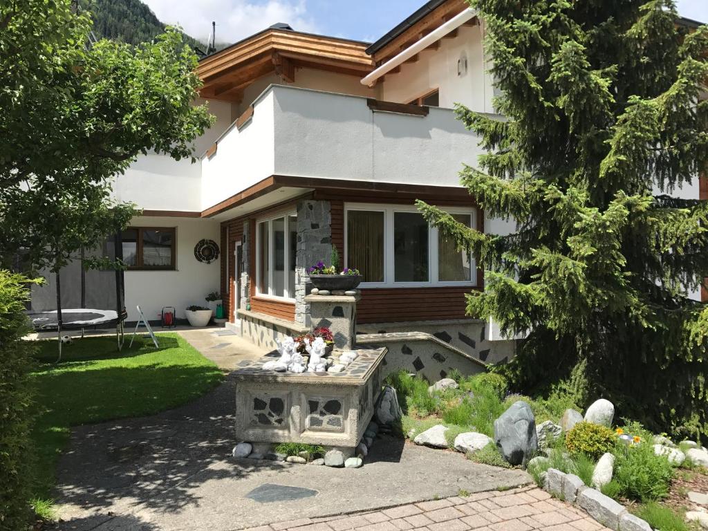 ein Haus mit einer Bank aus Stein davor in der Unterkunft Appartement Elisabeth in Umhausen