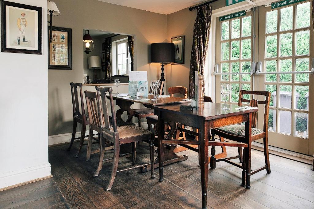 a dining room with a wooden table and chairs at Rose And Crown in Porthcawl