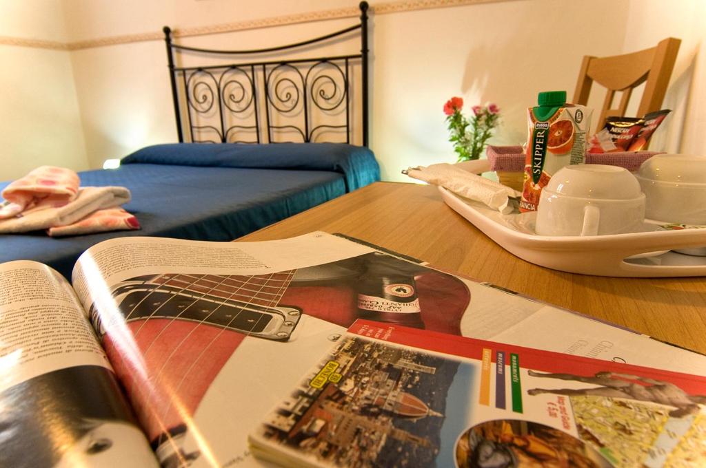 Soggiorno Primavera في فلورنسا: غرفة نوم بسرير وطاولة مع مجله