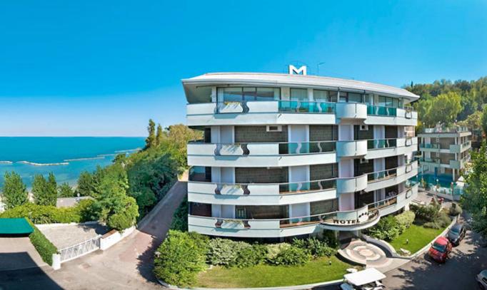 a large apartment building on top of a hill at Hotel Majestic in Gabicce Mare