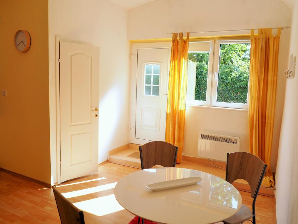 una camera con tavolo, sedie e finestra di Soča Apartment a Nova Gorica