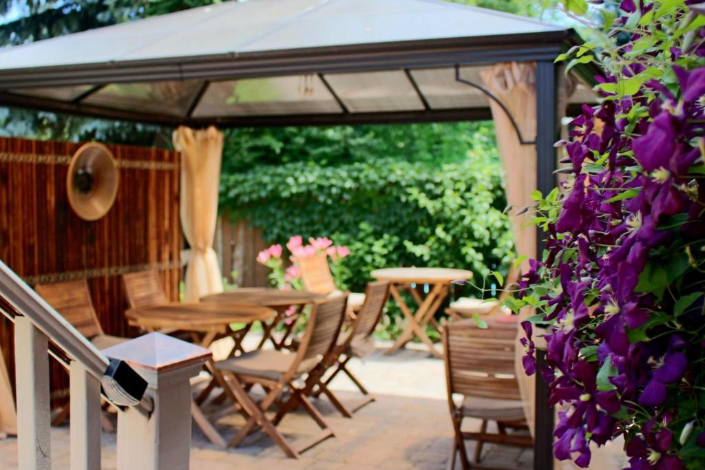 - un kiosque avec une table, des chaises et des fleurs violettes dans l'établissement Globetrotters B&B, à Niagara on the Lake