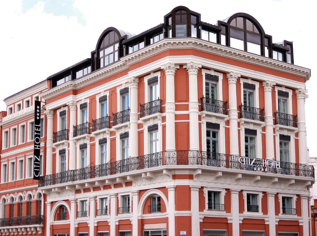 a large orange building with a balcony at Citiz Hotel in Toulouse