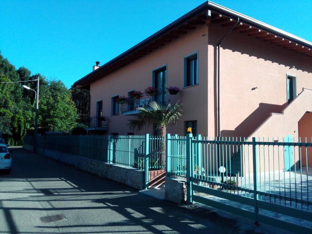 una casa rosa con una valla blanca y una puerta en Villa Ormeni, en Cardano al Campo