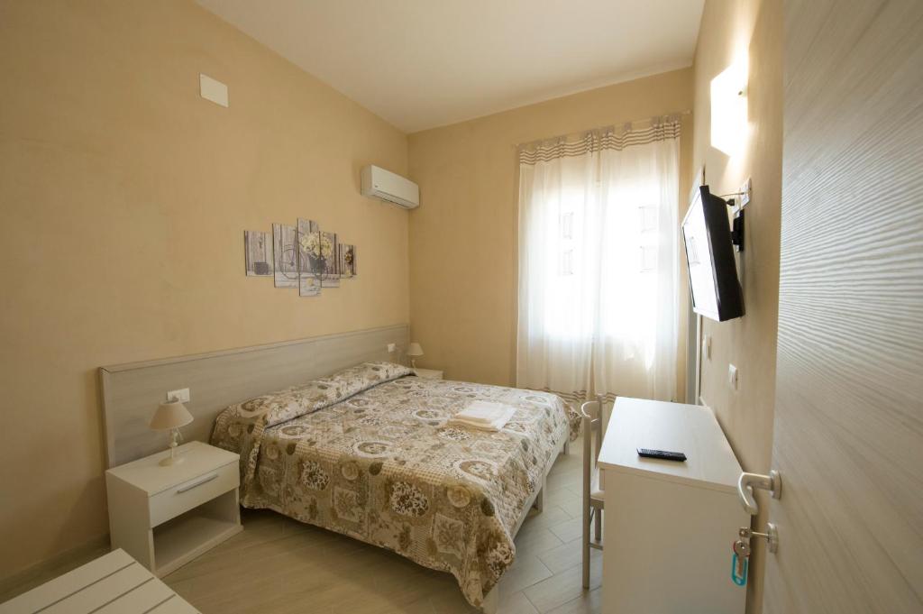 Habitación pequeña con cama y ventana en Vela Latina Affittacamere, en Marsala