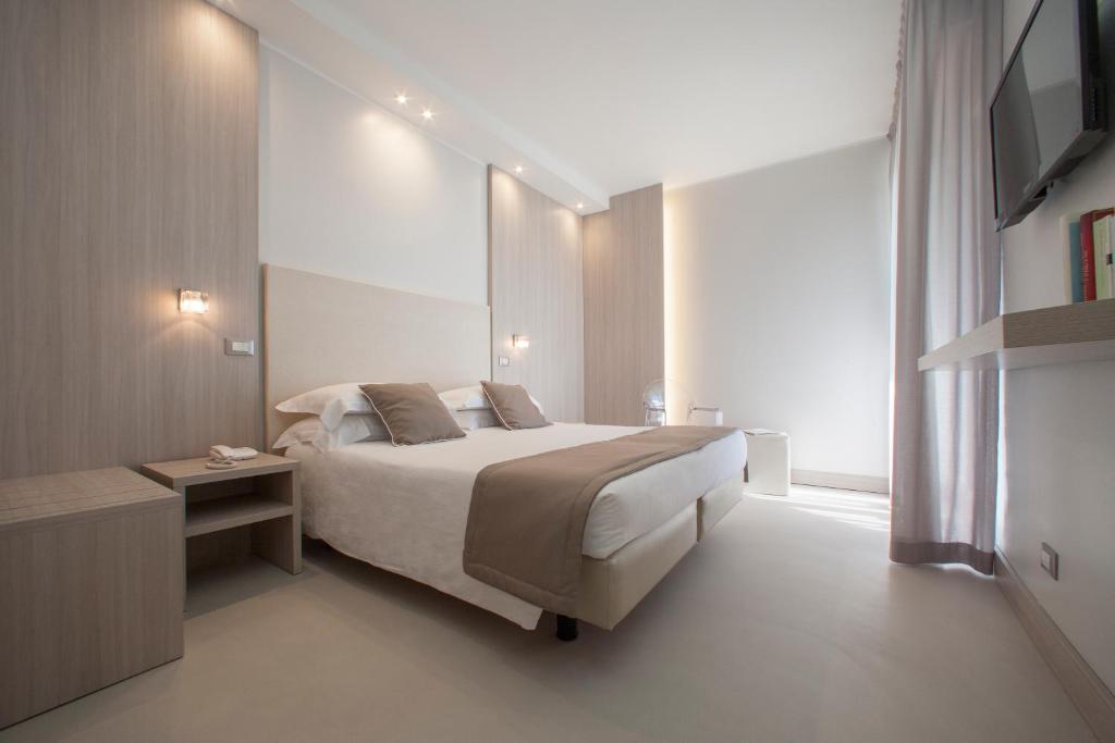 Hotel Delle Nazioni في ليدو دي يسولو: غرفه فندقيه بسرير ونافذه