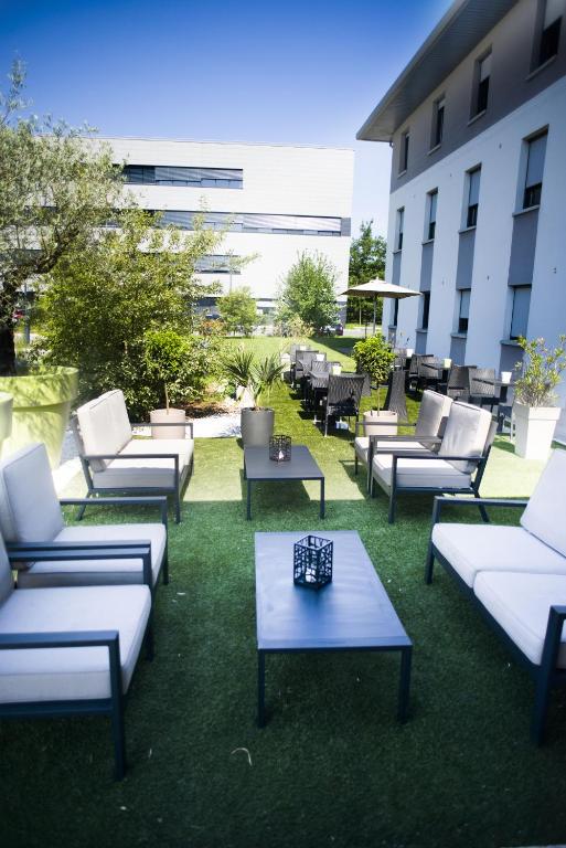 a group of couches and tables on the grass at Temis hôtel Besançon in Besançon