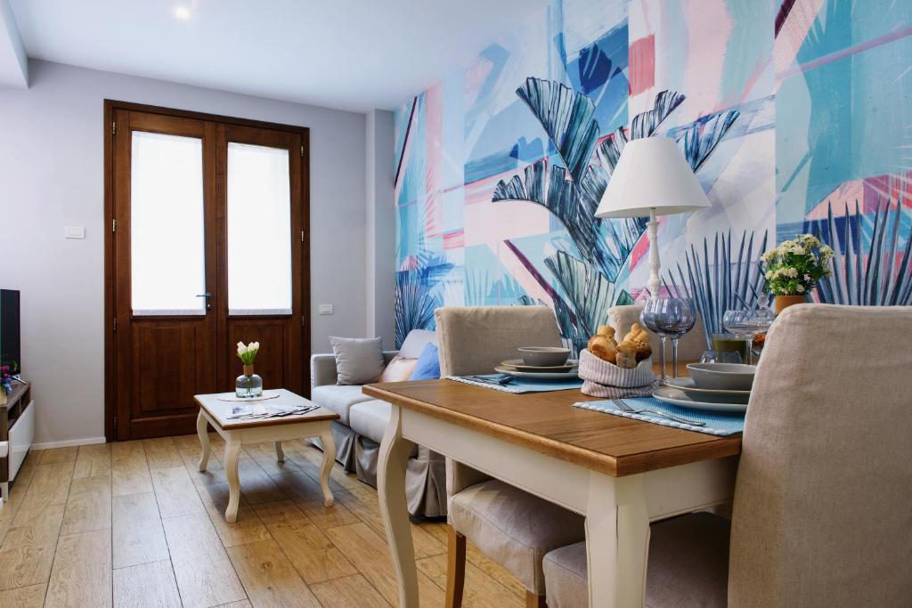 un comedor con mesa, sillas y una pintura en Lora Luxury House, en Como
