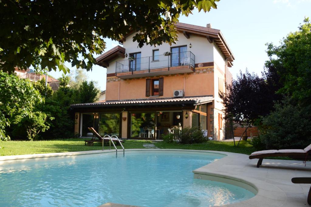 uma casa com piscina em frente a uma casa em Bhavantù em Boario Terme
