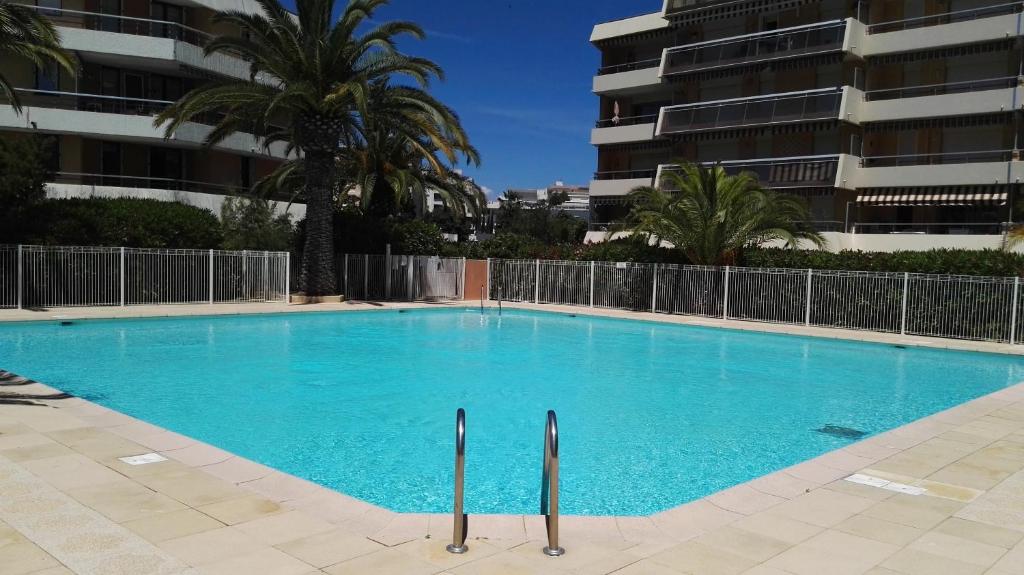 une grande piscine bleue devant un immeuble dans l'établissement Studio proche plage, Fréjus, à Fréjus