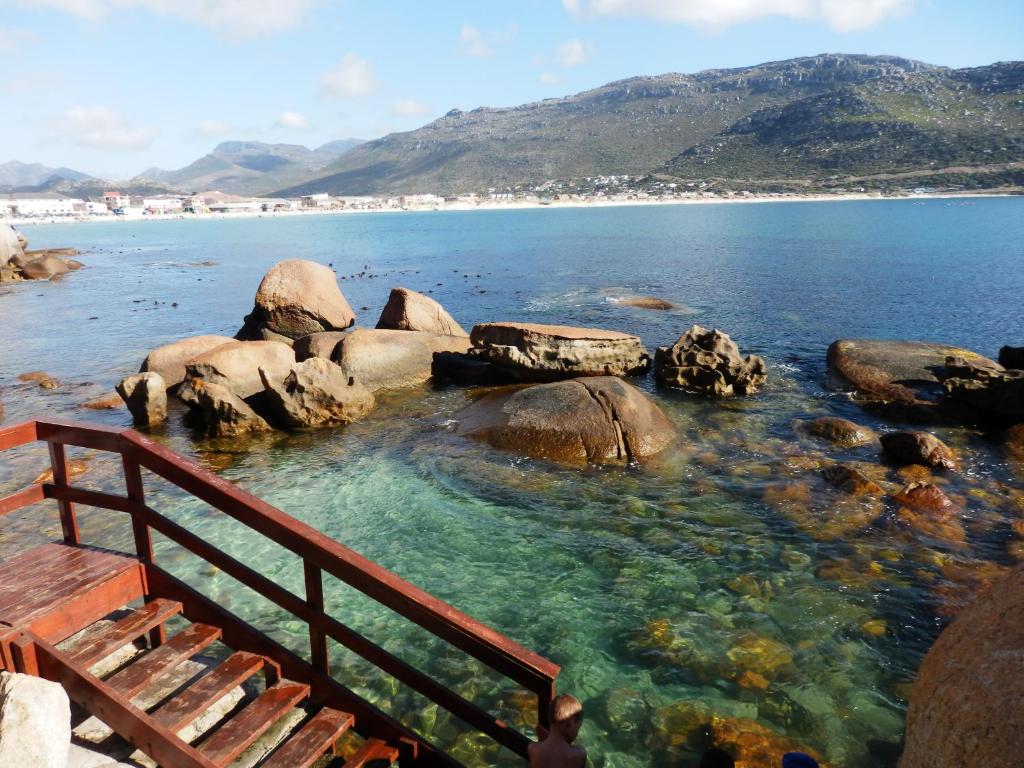 a person standing in the water near the beach at On-the-Rocks in Fish hoek
