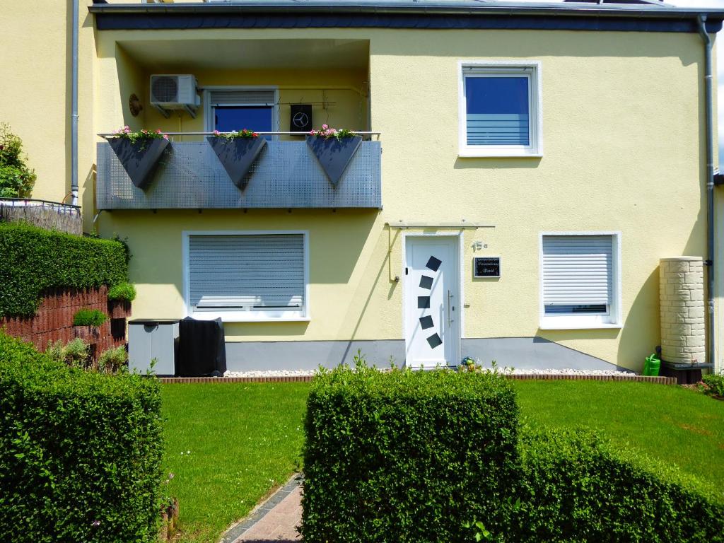 ein Haus mit einem Balkon mit Blumenkästen darauf in der Unterkunft Ferienwohnung David in Lorch am Rhein