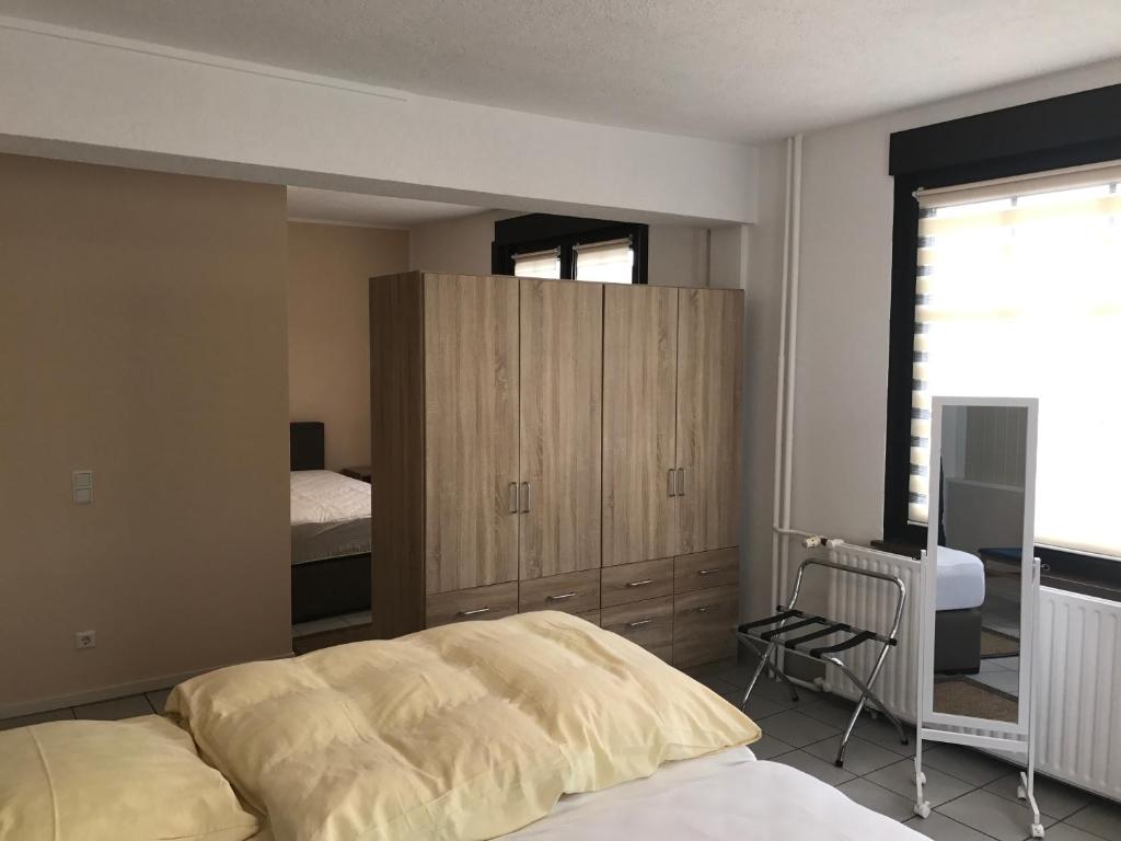 a bedroom with a bed and a wooden cabinet at Hotel Restaurant Alt Laubach in Laubach