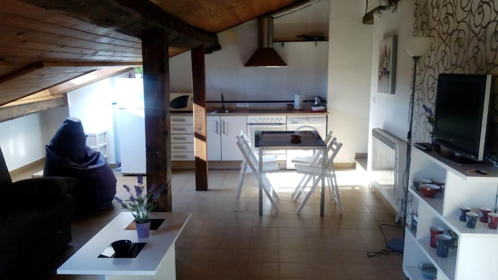 een keuken en een woonkamer met een tafel en stoelen bij Apartamento entreHoces Plaza Mayor in Cuenca