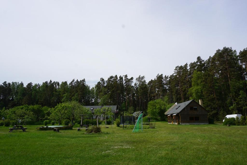 ein großes Feld mit einem Haus und einem Spielplatz in der Unterkunft Vecmuižas in Roja