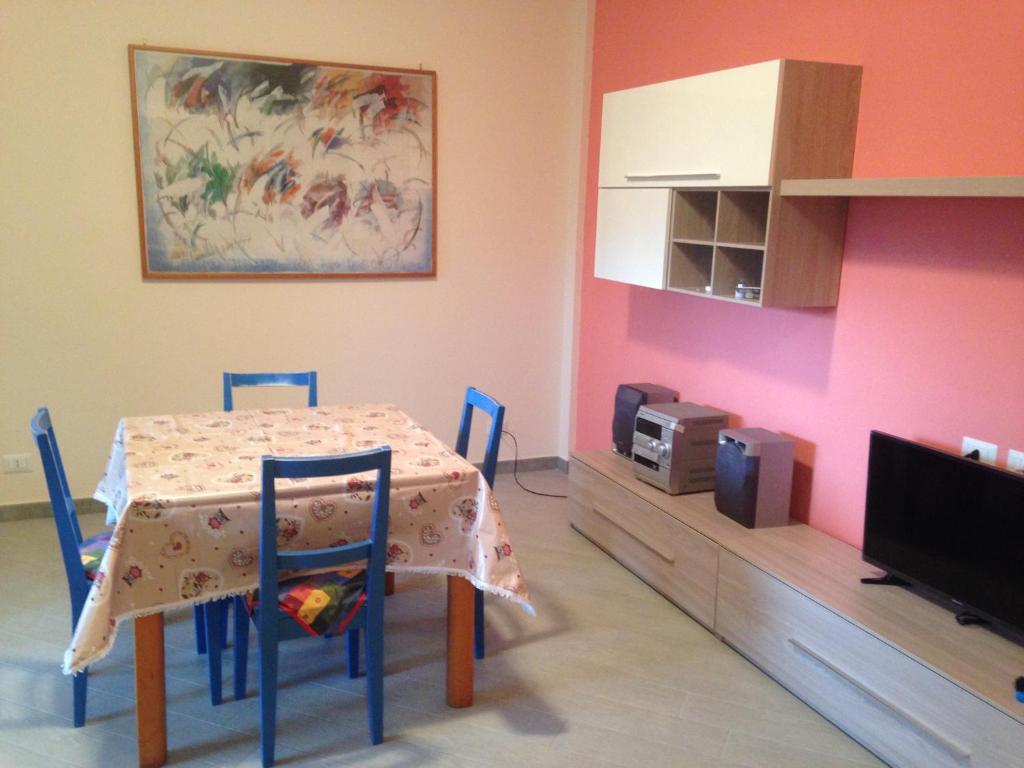 a dining room with a table and a tv at Alba Adriatica Olimpica in Alba Adriatica