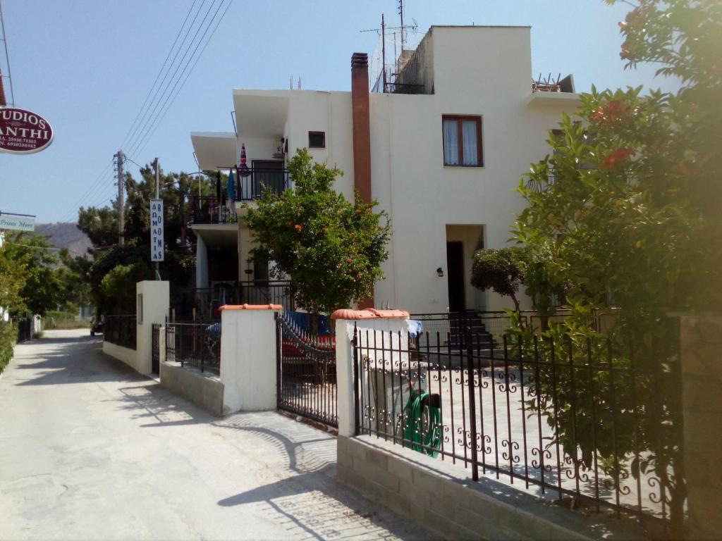 una casa blanca con una valla delante en Arleta's Sunny Guesthouse en Prinos