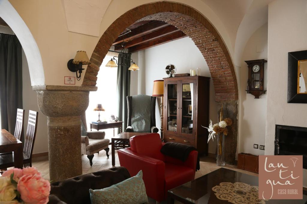 an archway in a living room with a red couch at LANTIGUA CASA RURAL in Hinojosa del Duque