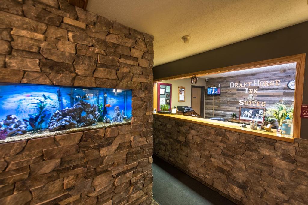 ArcadiaDraft Horse Inn and Suites的石墙中带鱼缸的餐厅