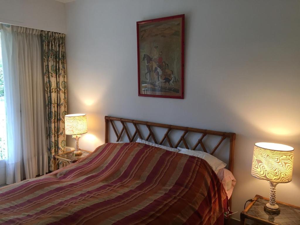 a bedroom with a bed with two lamps and a picture on the wall at Villa Bellochio in Menton