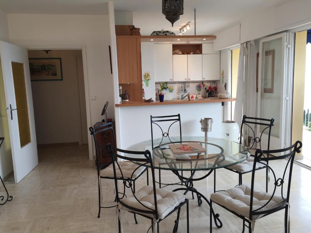 a dining room with a glass table and chairs at Villa Bellochio in Menton