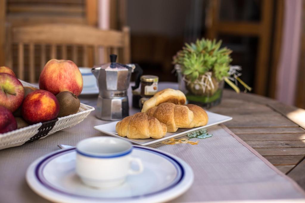 a table with plates of food and a cup of coffee at Villa il Poderino in Marina di Campo