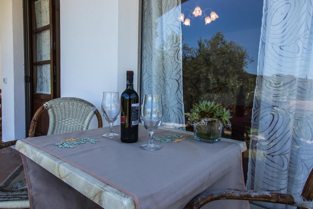 a bottle of wine sitting on a table with wine glasses at Villa il Poderino in Marina di Campo