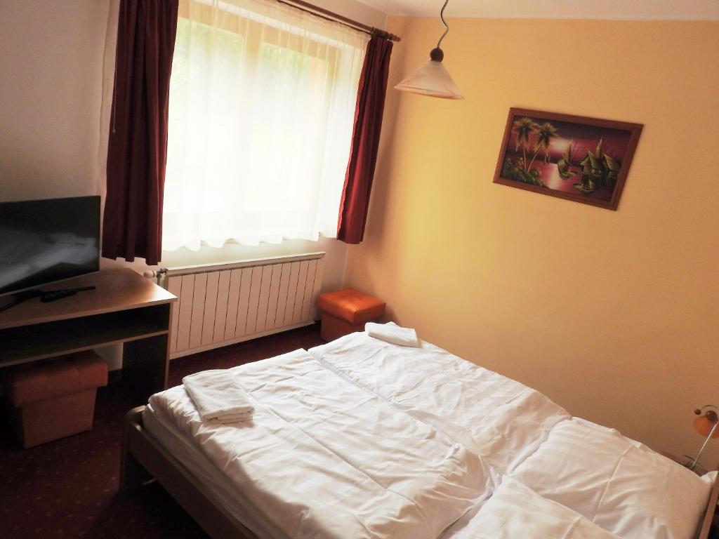 A bed or beds in a room at Penzion Montana