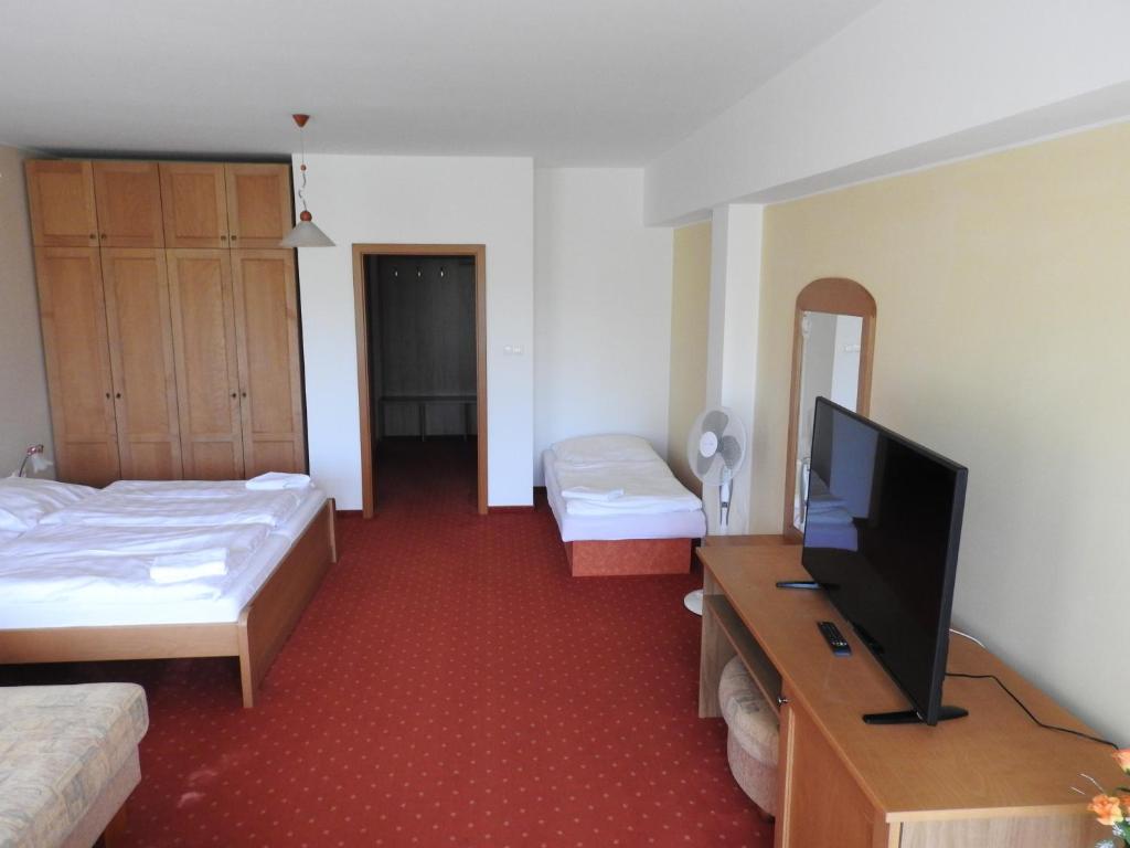 A bed or beds in a room at Penzion Montana