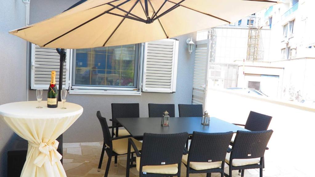 a table and chairs with a umbrella in a room at Superior Apartment CASA SPALATO in Split