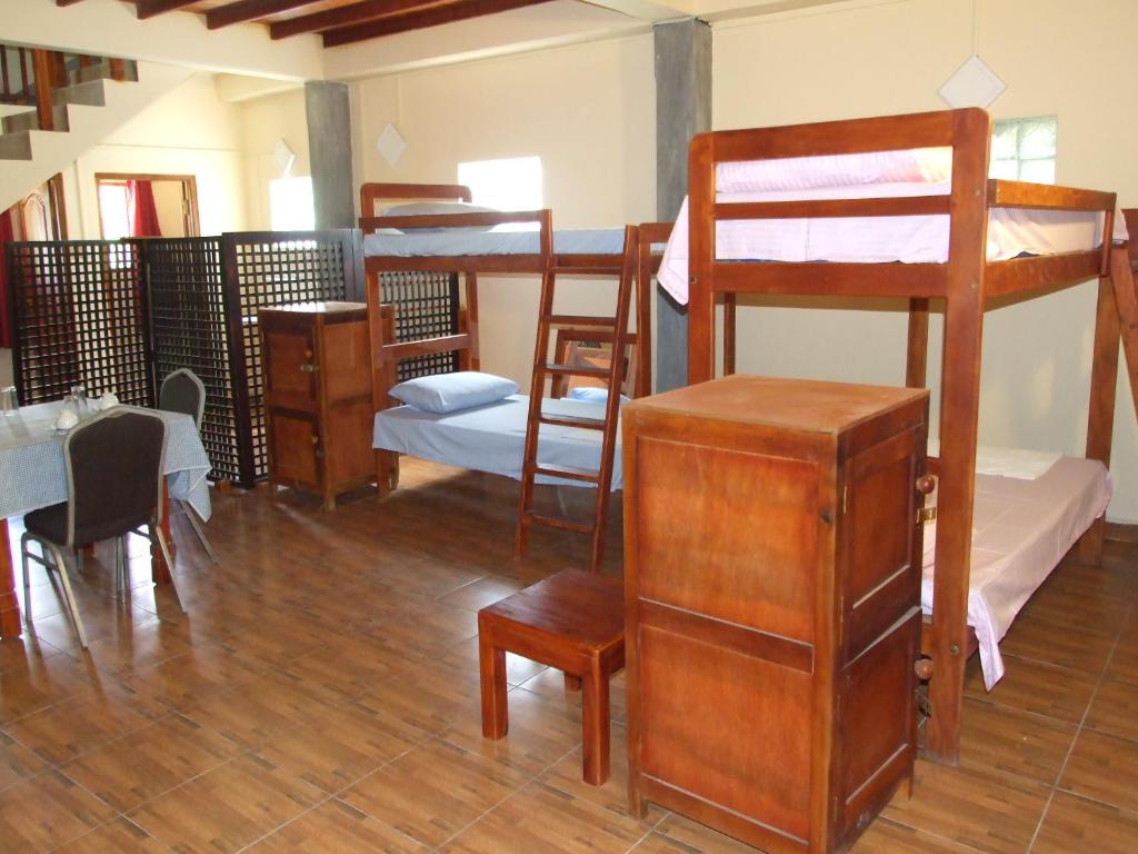 a room with several bunk beds and a table and chairs at Central City Hostel in Kandy