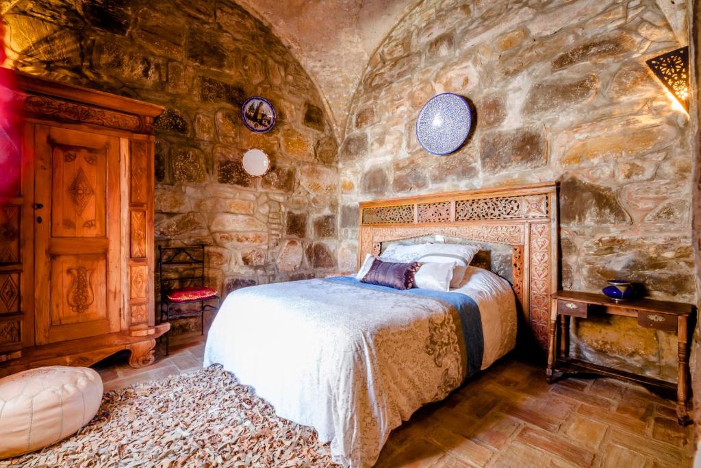 a bedroom with a bed and a stone wall at Hostal El Asturiano in Tarifa
