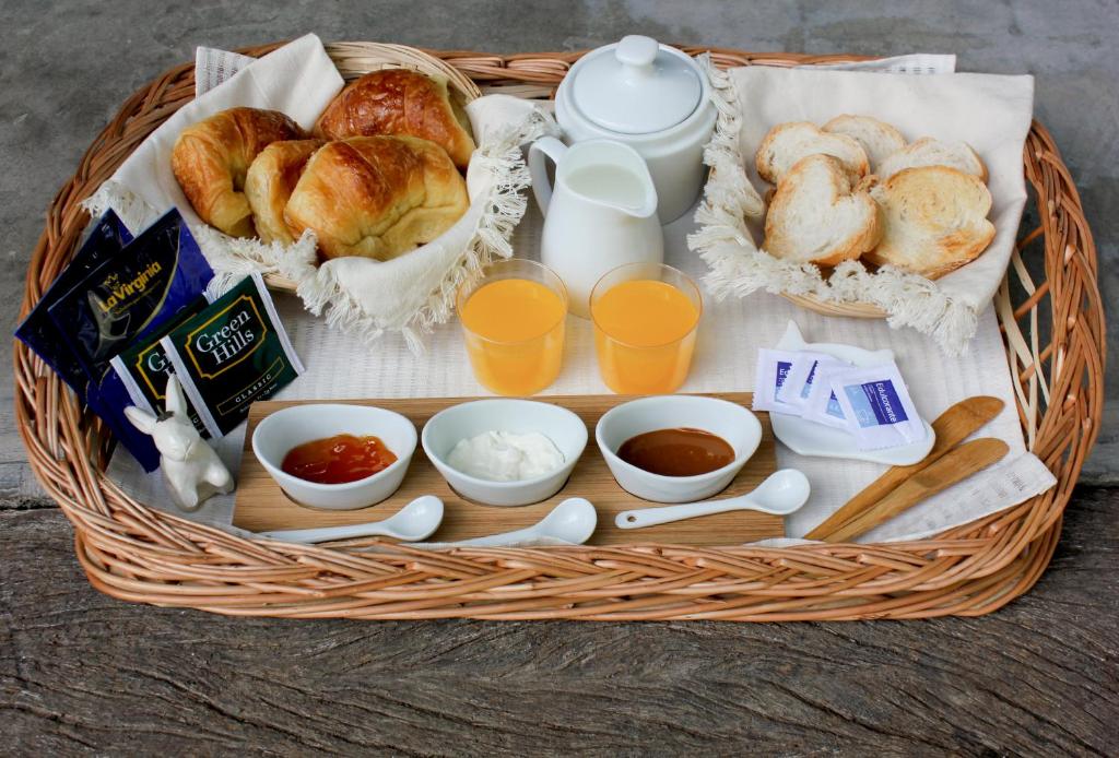 una cesta de comida con pan y tazas de zumo de naranja en El Remanso Chascomus en Chascomús