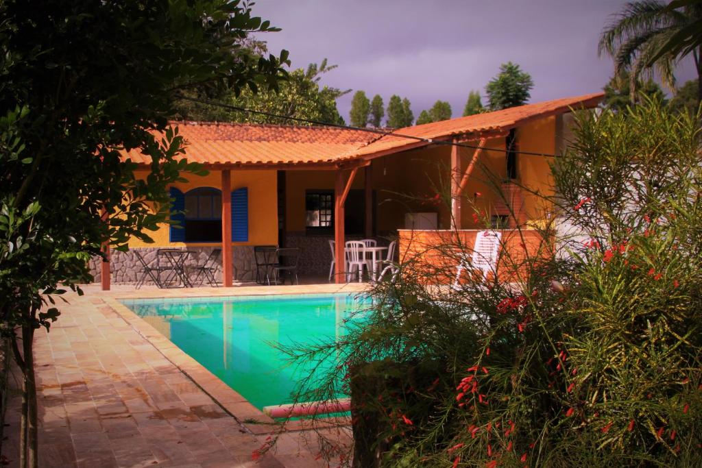 una casa con piscina frente a ella en Sitio Estrada Real de Tirandentes, en Santa Cruz de Minas