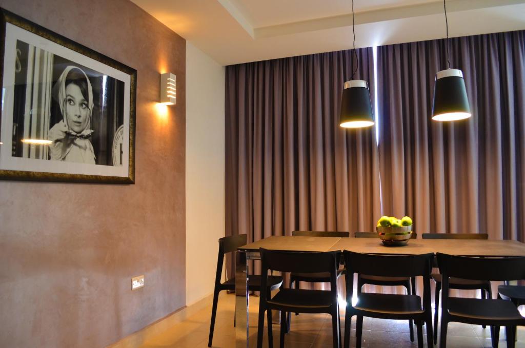 uma sala de jantar com mesa e cadeiras em Hepburn Holiday Apartment em Birżebbuġa