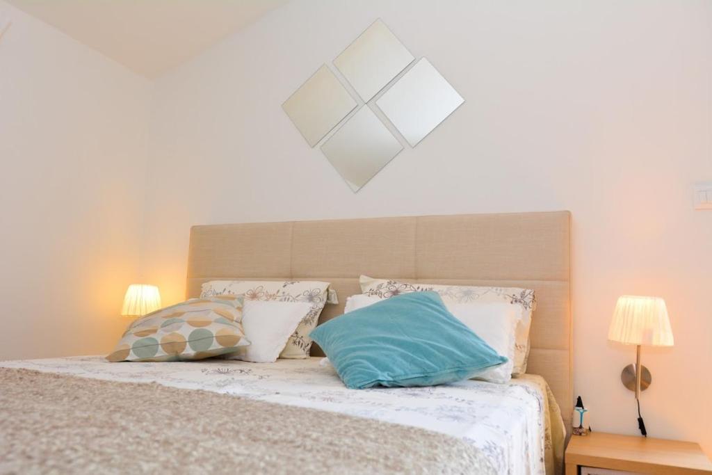 a bedroom with a bed with two pillows on it at Apartment and room Sveti Jakov in Dubrovnik